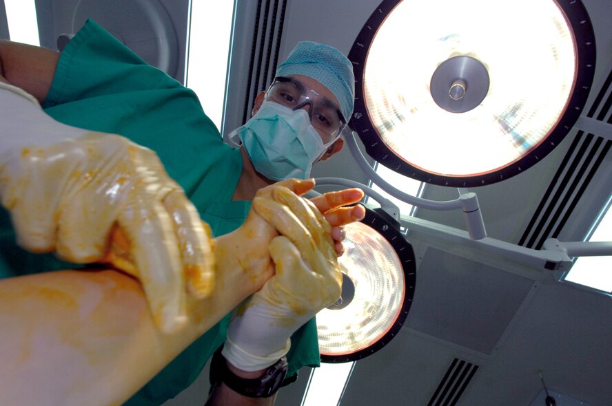 Airman 1st Class Emanuel White scrubs down the arm of a "patient" before surgery in the operating room Feb. 27 in the Air Force Theater Hospital at Balad Air Base, Iraq. Patient preparation and time management are crucial to an operation's success. Airman White is a 332nd Expeditionary Medical Operations Squadron surgical technician, who isdeployed from Lackland Air Force Base, Texas. The photo is taken from the patient's perspective. (U.S. Air Force photo/Senior Airman Julianne Showalter) 