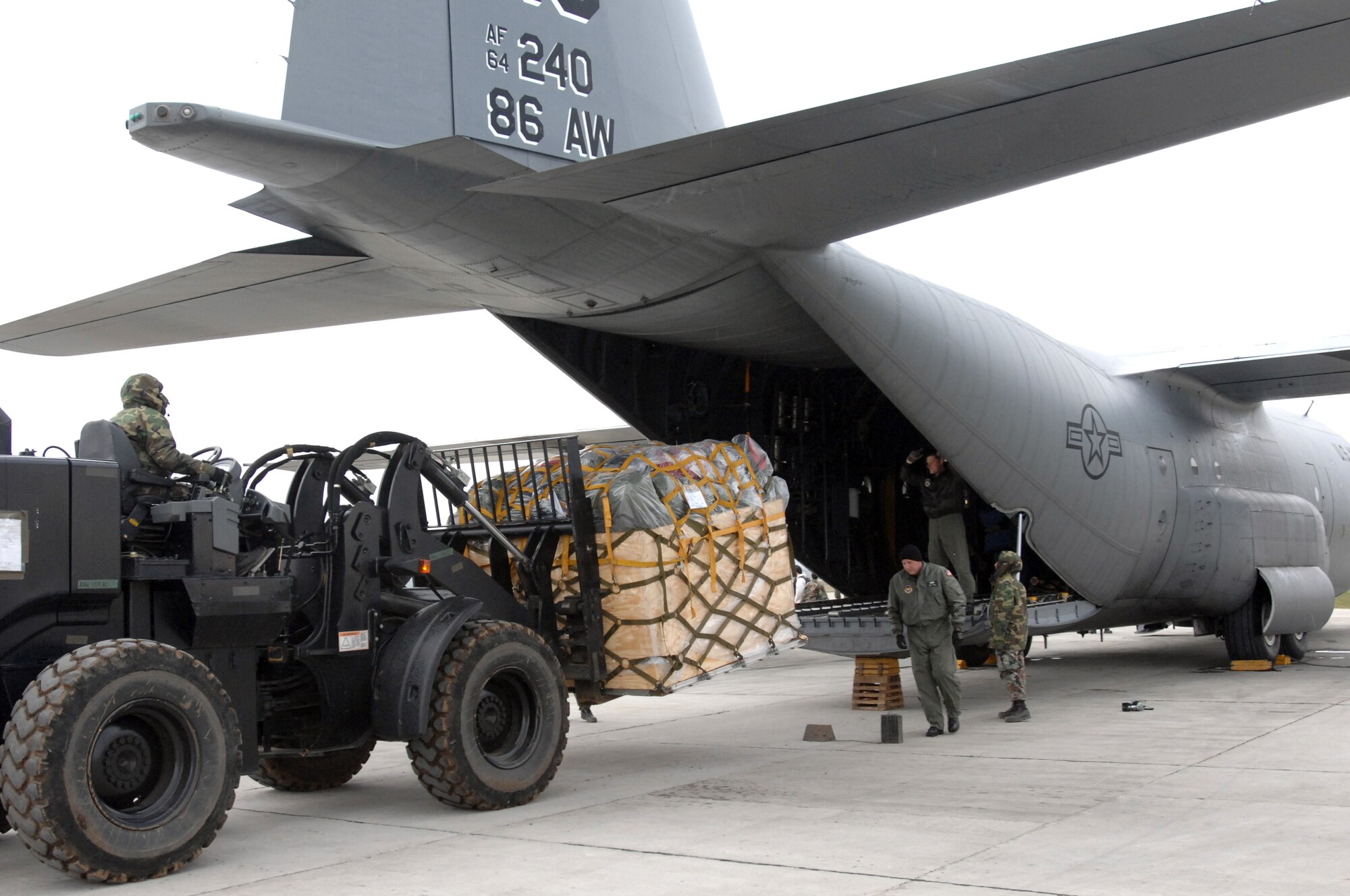 CAMPIA TURZII, Romania -- Members of the 404th Expeditionary Air Base Squadron unload pallets from a 86th Airlift Wing C-130 dropping off cargo and personnel here Mar. 25, 2008. A four-man team of Airmen received and processed more than 500,000 pounds of cargo here toward building up U.S. operations at the base in support of the NATO Summit.  The U.S forces are augmenting NATO by providing infrastructure and aircraft for the duration of summit in Bucharest Apr. 2-4.  (U.S. Air Force photo by Senior Airman Teresa M. Hawkins)(Released)
