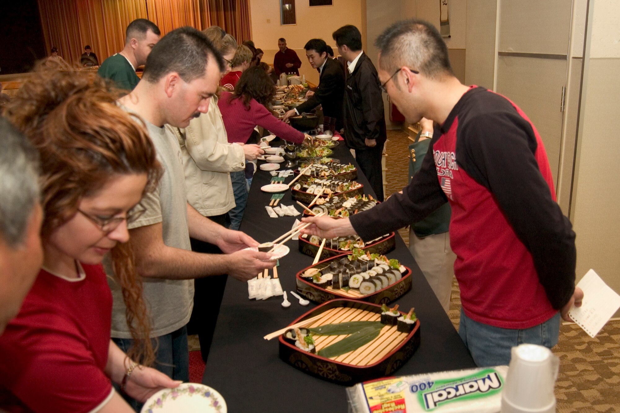MISAWA AIR BASE, Japan -- Toshi Takahashi serves food to hungry guests at the Mokuteki Community Center March 22, 2008. The food was part of the Ocha Kai celebration. (U.S. Air Force photo by Senior Airman Samuel Morse)