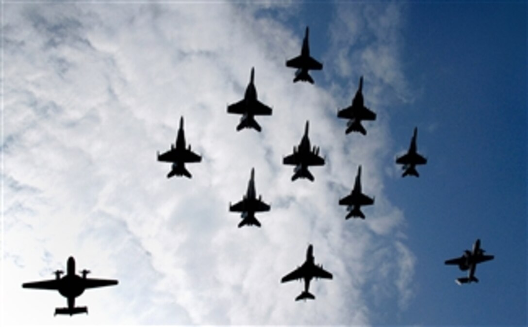 Aircraft fly in formation over the Nimitz-class aircraft carrier USS Abraham Lincoln during an air power demonstration in the U.S. 5th Fleet area of responsibility, March 30, 2008.