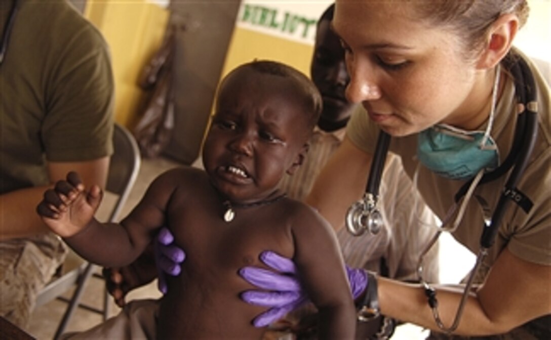 U.S. Army Sgt. Catherine Olivarez looks over a toddler during a Medical Civil Action Program at a village school in Goubetto Village, Djibouti, March 30, 2008. Olivarez is a medic assigned to the 354th Civil Affairs Brigade, Combined Joint Task Force Horn of Africa.