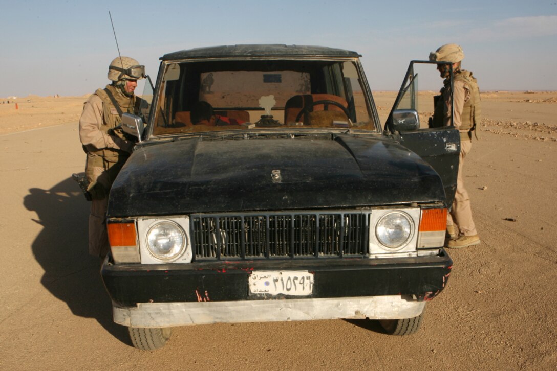 Maj. Matthew R. Black (right), company commander, and Gunnery Sgt. Devlin D. Root, company gunnery sergeant, both with Delta Company, 2nd Light Armored Reconnaissance Battalion, Regimental Combat Team 5, search a vehicle while patrolling through western Al Anbar province, Iraq, June 1. The company, known as "Outlaw," recently replaced Alpha Co., 2nd LAR, to be the direct front fighting force of Operation Defeat Al Queda in the North.
