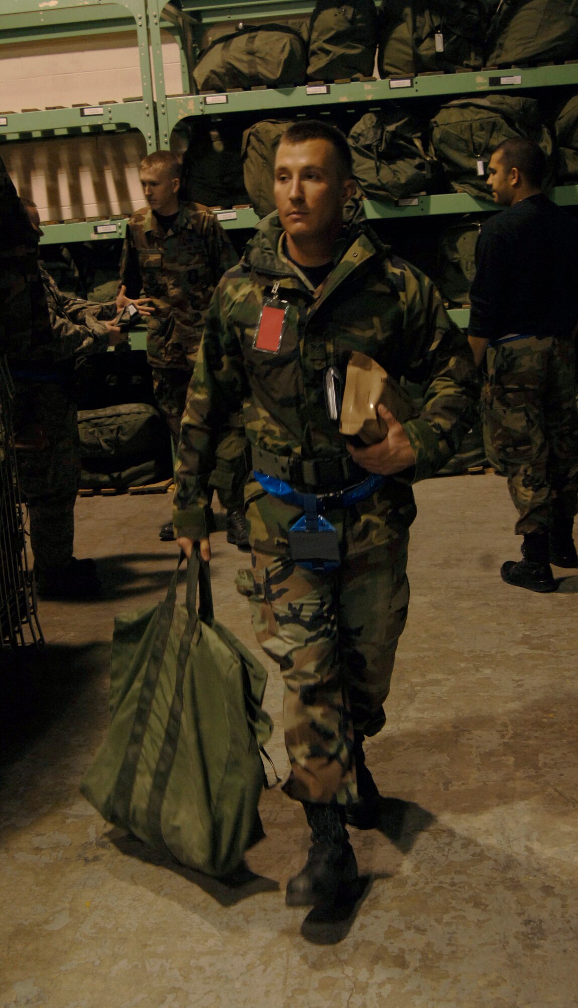 MCCONNELL AIR FORCE BASE, Kan. –- After acquiring an A-Bag, Senior Airman John Mass, 22nd Communication Squadron, walks to the equipment issue line at Bldg. 1090, March 29. The 22nd Logistics Readiness Squadron’s Equipment Issue is where Airmen pick up web belts, canteens, Mission Oriented Protective Posture Gear for exercises and real world issue. (Photo by Senior Airman Roy Lynch III)