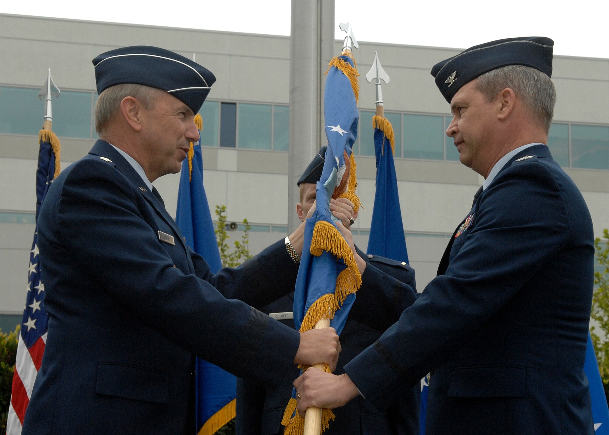 SMC Commander Lt. Gen. Michael Hamel passes the guide-on to Col. Christopher Pelc during a ceremony that marked the activation of SMC's Missile Defense Systems Group, April 1. Col. Pelc accepted the flag and assumes the title as the Group's Director. He will be responsible for activities associated with program execution of the Space Tracking and Surveillance System research and development program, Near Field Infrared Experiment and Advanced Technology Risk Reduction effort. (Photo by Stephen Schester)