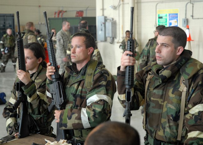 Airmen from various sections gather around a training table with their M16s in hand and pay attention to the 437th Security Forces Squadron training instructors on proper firing, clearing and cleaning of the M16 Assault Rifle during ability to survive and operate training on base Wednesday.  (U.S. Air Force photo/Airman 1st Class Timothy Taylor)