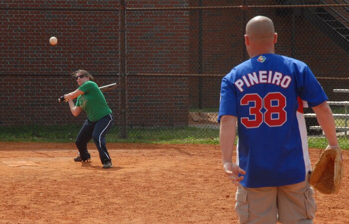 Shay Litton takes a whack at a ball pitched by Jos? Pi?eiro during a softball game for Wingman Day on base Tuesday. Squadrons participated in various events to provide Airmen information to create a culture of responsible choices. Litton is with the 437th Medical Group Mental Health Clinic and Pi?eiro is with the 437th Medical Operations Squadron. (U. S. Air Force photo/Airman 1st Class Melissa White)