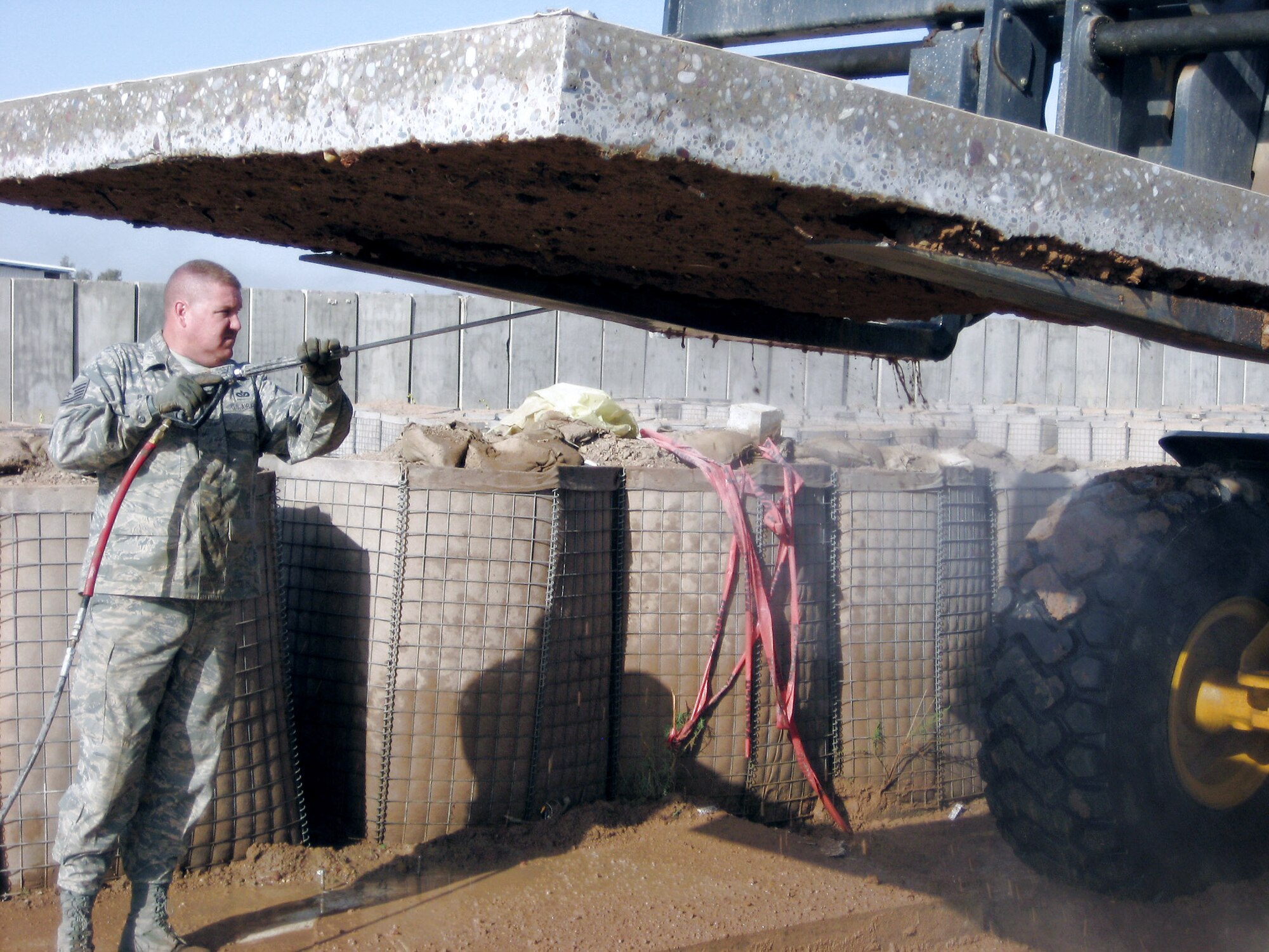 Tech. Sgt. Jeffrey Barry  pressure sprays excess dirt from the bottom of a section of floor from the original Air Force Theater Hospital March 1 at Balad Air Base, Iraq. The floor section is being cleaned prior to transporting to the National Museum of Health and Medicine in Washington. The origianl hopital has earned the recognition of being the location where the most lives were lost and saved in the Iraq theater of operations. Sergeant Barry is a 332nd Expeditionary Civil Engineer Squadron heating, ventilation and air conditioning technician deployed from Luke Air Force Base, Ariz. (U.S. Air Force photo/Maj. Scott Bryant) 