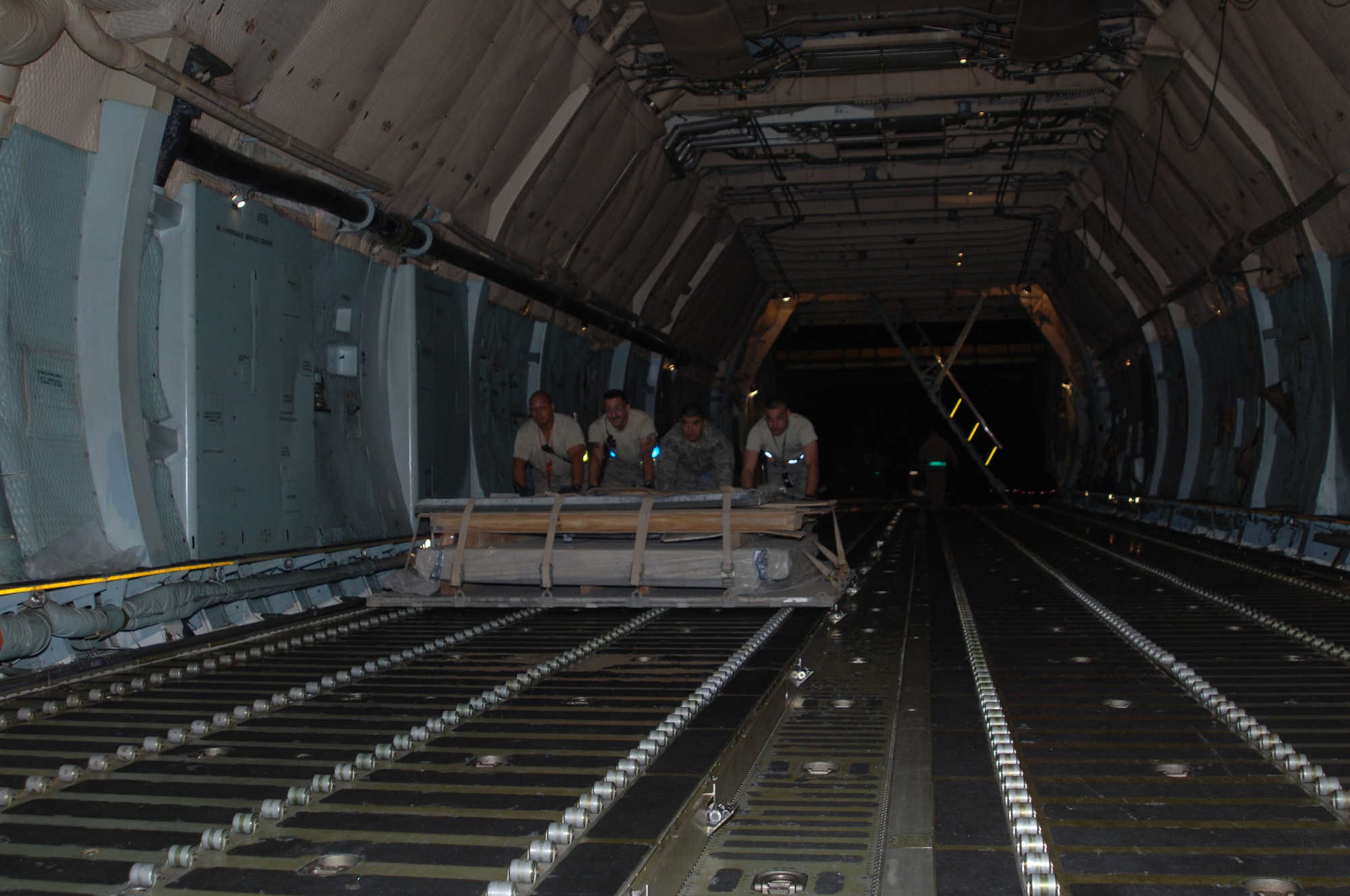 BALAD AIR BASE, Iraq -- (From left) Tech. Sgt. Peter Aguilar, Tech. Sgt. Dana Dupuis, Tech. Sgt. Daniel Varley and Master Sgt. Rene Guerrero, 332nd Expeditionary Logistics Readiness Squadron aerial port flight Airmen, push the pallet containing Bay II onto a C-5 Galaxy here, April 1. Bay II is on its way to the National Museum of Health and Medicine in Washington, D.C., where it is slated for exhibition because it is known, by the medical community, as the place where the most American blood was spilled since the Vietnam War. (U.S. Air Force photo/ Master Sgt. Heather Cabral)