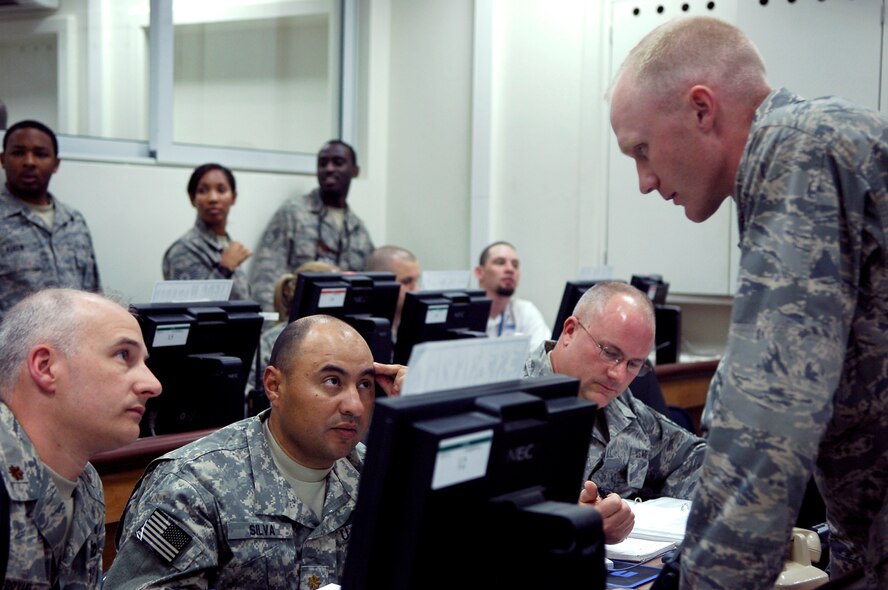 BALAD AIR BASE, Iraq -- Maj. John Vipperman, a civil engineer with the Logistics Support Area Anaconda Mayor Cell, confers with Maj. Scott Bryant, 332nd Expeditionary Civil Engineer Squadron and Maj. John Silva, 76th Combat Infantry Brigade about civil engineer matters in the Joint Emergency Operations Center during a battle drill here, March 31. Air Force and Army counterparts worked together in the Joint Emergency Operations Center to restore the base to normal wartime operations and to take care of simulated injured people. Major Vipperman is deployed from Grand Forks Air Force Base, N.D., Major Bryant is deployed from Tyndall Air Force Base, Fla., and Major Silva is deployed from the Indiana National Guard. (U.S. Air Force photo /Staff Sgt. Mareshah Haynes)