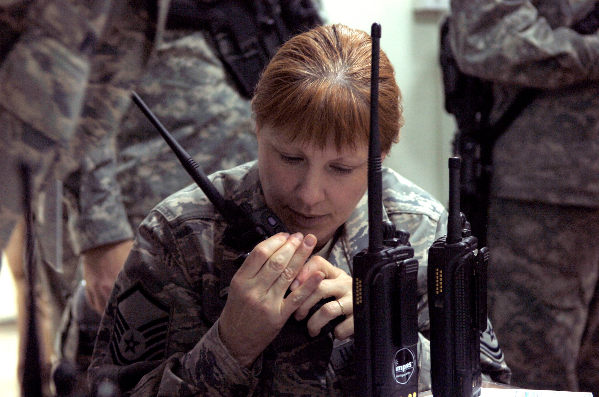 BALAD AIR BASE, Iraq -- Master Sgt. Jenny Luttrell, 332nd Expeditionary Air Wing Antiterrorism Force Protection office, communicates with role players at simulated incident sites from the Joint Emergency Operations Center during a battle drill here, March 31. Sergeant Luttrell is deployed from Ramstein Air Base, Germany. (U.S. Air Force photo /Staff Sgt. Mareshah Haynes)
