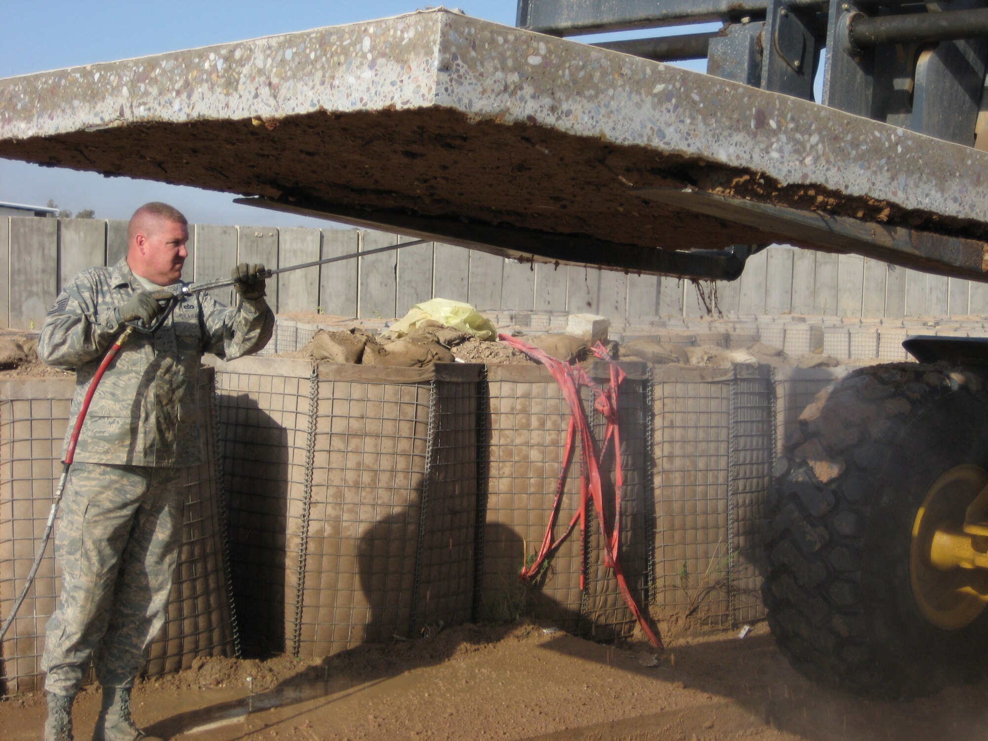 BALAD AIR BASE, Iraq -- Tech. Sgt. Jeffrey Barry, 332nd Expeditionary Civil Engineer Squadron heating, ventilation and air conditioning technician pressure sprays excess dirt from the bottom of Bay II prior to transporting to the National Museum of Health and Medicine in Washington, D.C. Bay II has earned the recognition of being the location where the most lives were lost and saved in the Iraq theater of operations. Sergeant Barry is deployed from Luke Air Force Base, Ariz. (U.S. Air Force photo/ Maj. Scott Bryant)