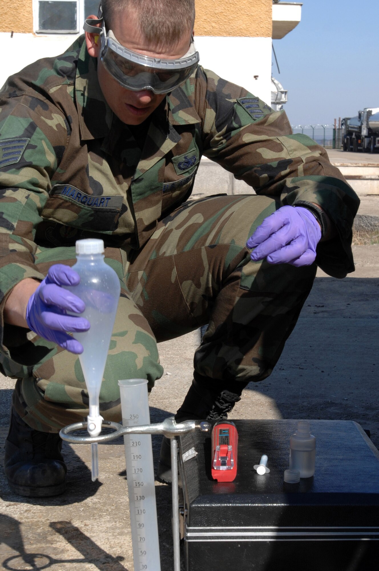 CAPMIA TURZII, Romania -- Staff Sgt. Jeff Marquart, 404th Expeditionary Air Base Squadron fuels laboratory technician, puts a sepatory funnel back into it holder while testing fuel here March 29, 2008.  Ensuring a safe fuel supply is critical for the Air Force operations at this Romanian base.  The expeditionary unit is deployed here to augment NATO and Romanian forces in securing the airspace above the NATO Summit being held in Bucharest April 2-4.  (U.S. Air Force photo by Senior Airman Teresa M. Hawkins)