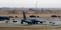 MINOT AIR FORCE BASE, N.D. -- A convoy travels in the shadow of a B-52H Stratofortress as part of a mini-generation exercise here March 28. The mini-gen was one of several areas assessed during an initial nuclear surety inspection here March 24 to 29. (U.S. Air Force photo by Airman 1st Class Kelly Timney)