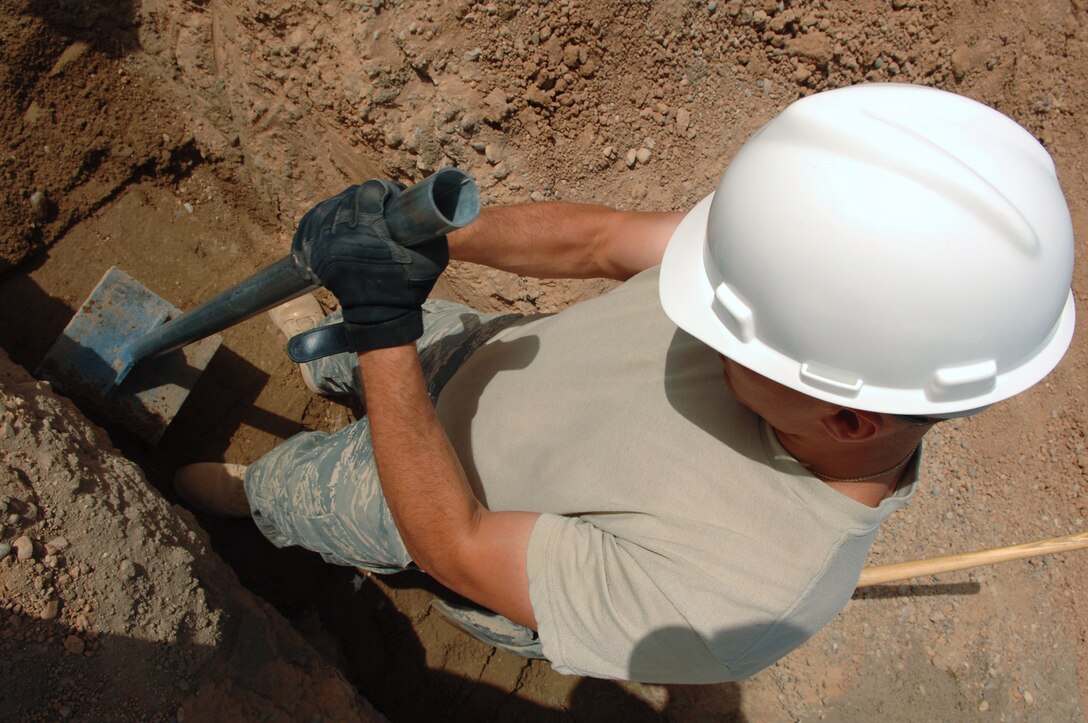 Staff Sgt. Steven Lucero compacts sand around water pipes to provide protection from rocks March 24 at Balad Air Base, Iraq. Base plumbers are in the midst of a pipe infrastructure replacement project involving removal of old pipes and replacing them with newer, thicker gauge pipes that will stabilize the systems. Sergeant Lucero is a 332nd Civil Engineer Squadron plumber deployed from Ellsworth Air Force Base, S.D. (U.S. Air Force photo/Senior Airman Julianne Showalter) 
