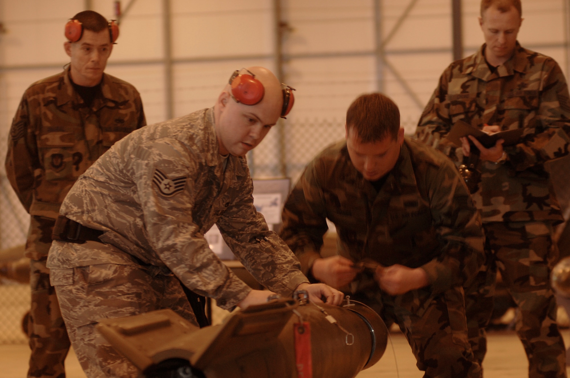 Staff Sgt. Jason Wright, weapons load team chief and Staff Sgt. Christopher Yones, load team member, prepare a GBU-12 to be loaded on the aircraft as part of the 48th Aircraft Maintenance Squadron Strike Weapons Aircraft Maintenance Unit team during the annual load crew competition March 8 at RAF Lakenheath, England. (U.S. Photo by Airman 1st Class Erika Brooke) 