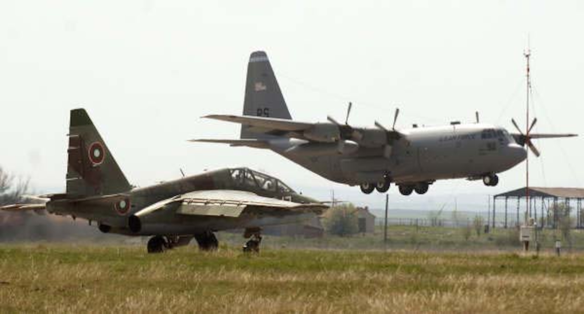 A Bulgarian Air Force SU-26 Frogfoot taxis past a C-130E Hercules at Bezmer Air Base, Bulgaria before conducting a tactical sortie for Exercise Thracian Spring 2008. Four Hercules from the 37th Air Lift Squadron and approximately 170 aircrew and support personnel assigned to the 86th Air Lift Wing and 435th Air Base Wing at Ramstein Air Base, Germany are being hosted by the Bulgarian military for the annual bilateral training exercise between the United States and Bulgaria. Photo by Master Sgt. Scott Wagers / (released)