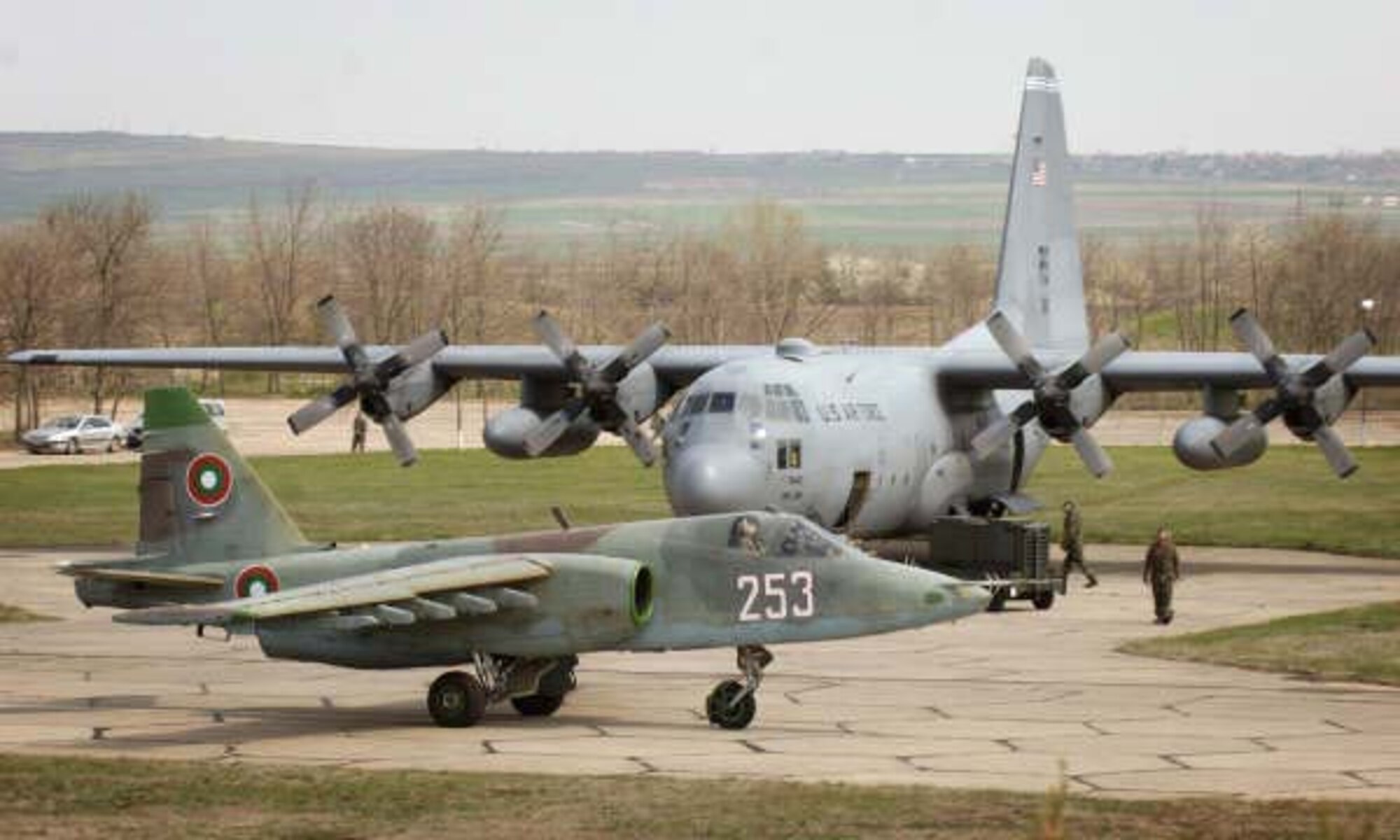 A Bulgarian Air Force SU-26 Frogfoot taxis past a C-130E Hercules at Bezmer Air Base, Bulgaria before conducting a tactical sortie for Exercise Thracian Spring 2008. Four Hercules from the 37th Air Lift Squadron and approximately 170 aircrew and support personnel assigned to the 86th Air Lift Wing and 435th Air Base Wing at Ramstein Air Base, Germany are being hosted by the Bulgarian military for the annual bilateral training exercise between the United States and Bulgaria. Photo by Master Sgt. Scott Wagers / (released)