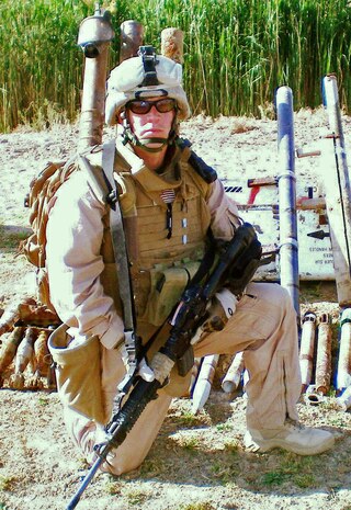 A criminal attorney in his civilian job, HM2 Adam F. Kinney, a Navy Corpsman with 2nd Bn., 24th Marines, poses for a photo in Habbaniyah, Iraq. Kinney is serving with the battalion during its seven-month deployment in the al Anbar Province of Iraq.