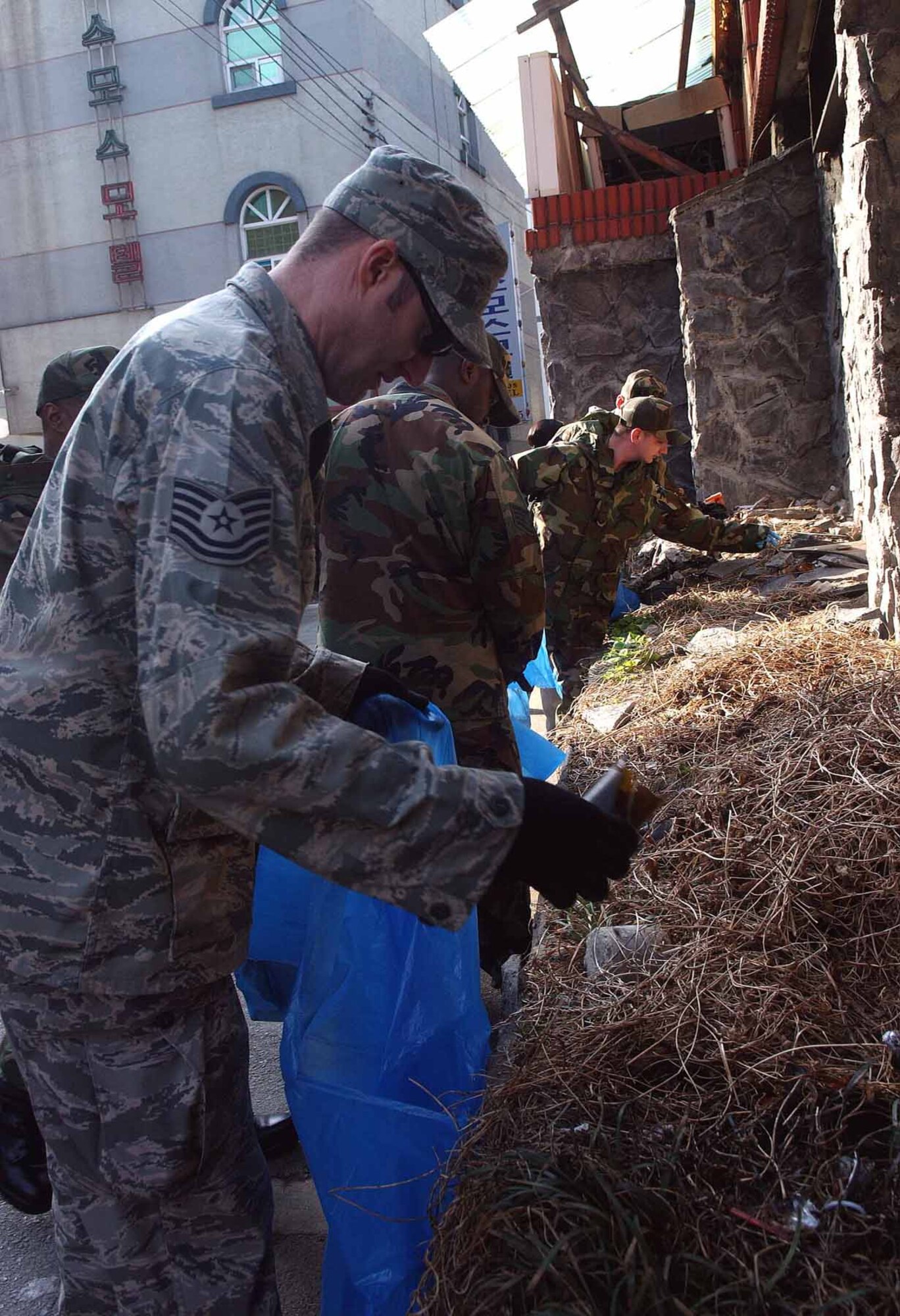 OSAN AIR BASE, Republic of Korea -- Volunteers removes debris as part of Osan’s Earth Day/Arbor Day celebrations April 3. Volunteer clean-up crews clean a nearby park; the shopping mall outside the main gate and from the Main Gate to Doolittle to base exchange. (U.S. Air Force photo/Staff Sgt. Candy Knight)