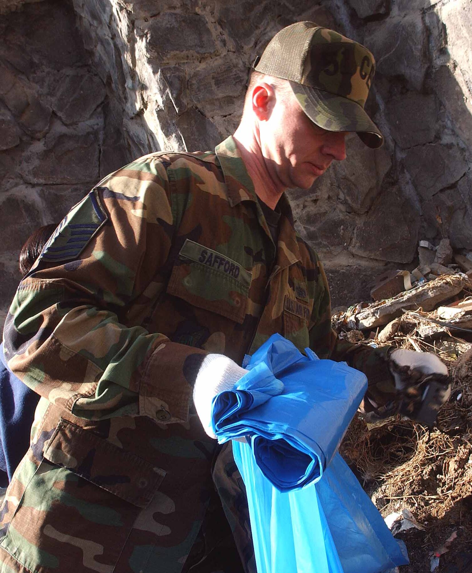 OSAN AIR BASE, Republic of Korea -- Master Sgt. Jeffrey Safford, 51st Civil Engineer Squadron, places litter inside his trash bag during a clean-up of the shopping mall outside the main gate April 3. The clean-up was part of Osan's Earth Day/Arbor Day celebrations. (U.S. Air Force photo/Staff Sgt. Candy Knight)