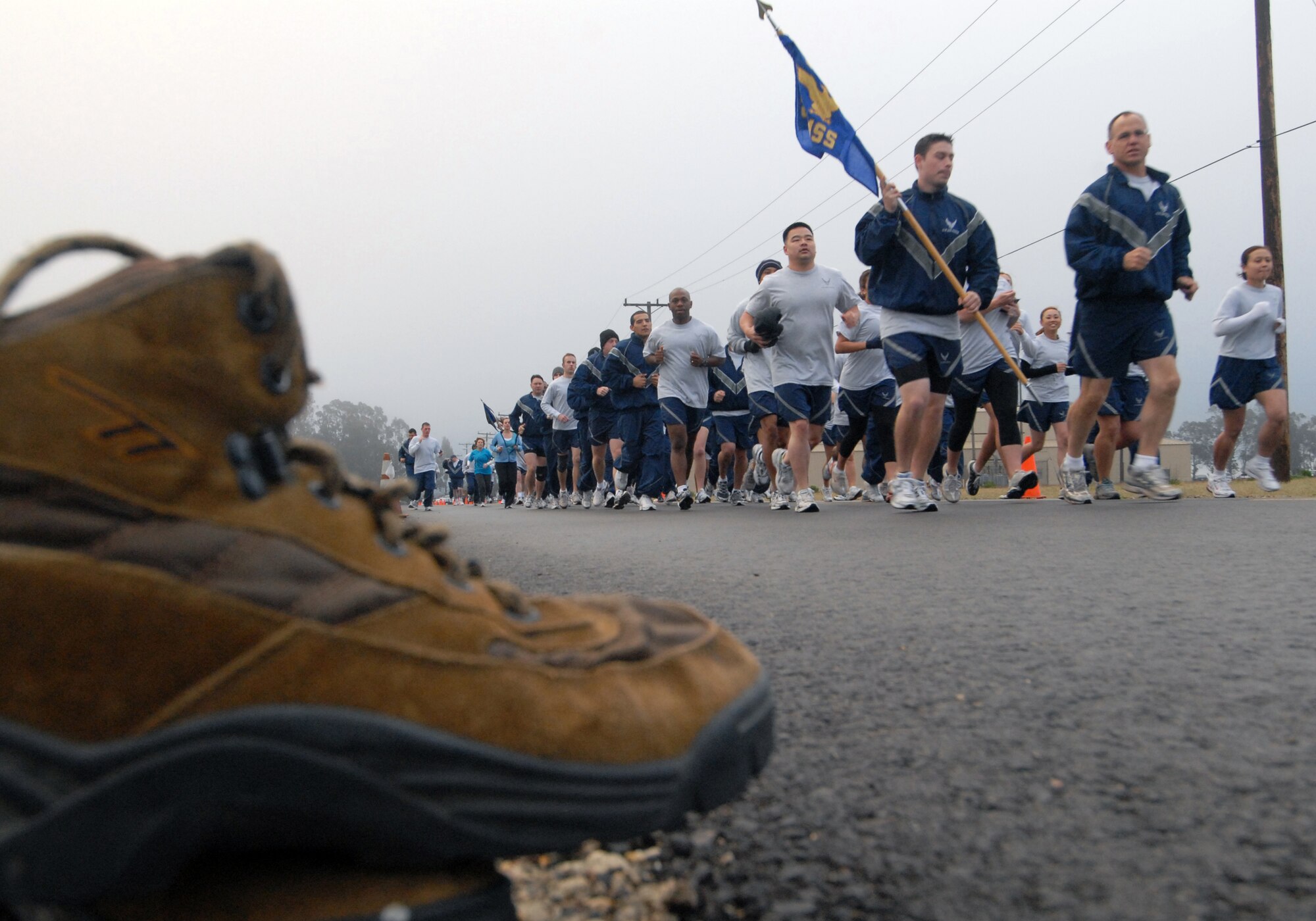 VANDENBERG AIR FORCE BASE, Calif. -- Airmen of the 30th Mission Support Squadron run past a mile stretch of shoes during the beginning of the Fit-to-Fight Run here, on April 3. Volunteers lined the first mile of the course with shoes to represent sexual assault survivors. Many Airmen wore the same teal shirts as the volunteers to support sexual assault survivors and prevention.(U.S. Air Force photo/Senior Airman Christopher Hubenthal)