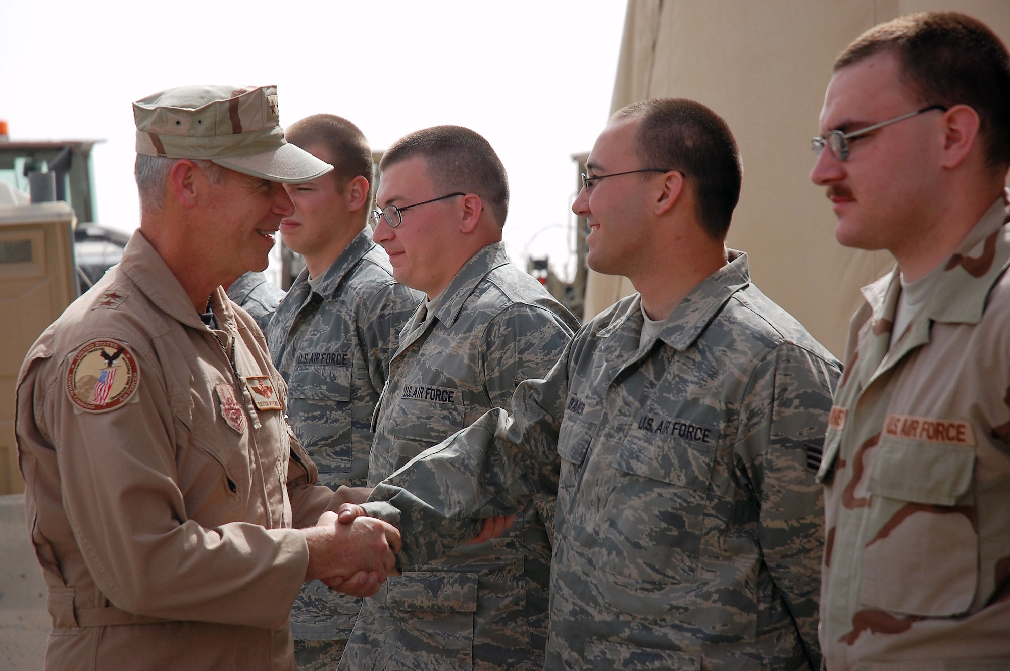 Maj. Gen. William L. Holland shakes hands with Senior Airman Andrew Baker April 2 at a Southwest Asian air base. General Holland is the 9th Air Force vice commander and the deputy commander of U.S. Air Forces Central from Shaw Air Force Base, S.C. He visited the area of responsibility to thank the Airmen for what they do and to take back any inputs on how to better train and equip the Airmen supporting operations Iraqi Freedom and Enduring Freedom. Airman Baker is a member of the 386th Expeditionary Logistics Readiness Squadron deployed from Dover Air Force Base, Del. (U.S. Air Force photo/Staff Sgt. Patrick Dixon) 
