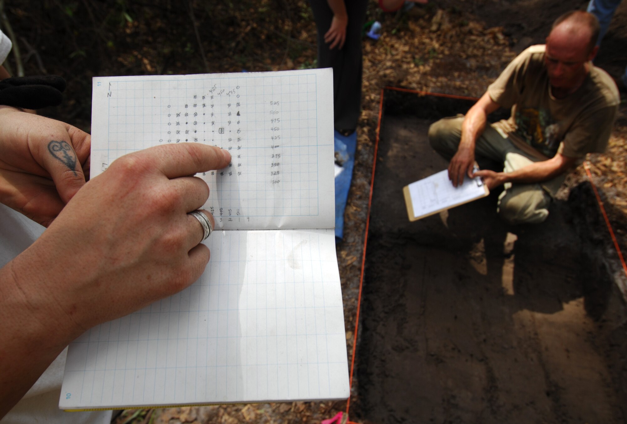 MOODY AIR FORCE BASE, Ga. -- A contracted archeologist from Stone Mountain, Ga., points out shovel test areas in a grid around a recent dig site on Moody's Grand Bay range April 1. Shovel tests are being conducted here to determine whether or not artifacts exist and the site should be protected.   (U. S. Air Force Photo/Staff Sgt. Joshua T. Jasper)