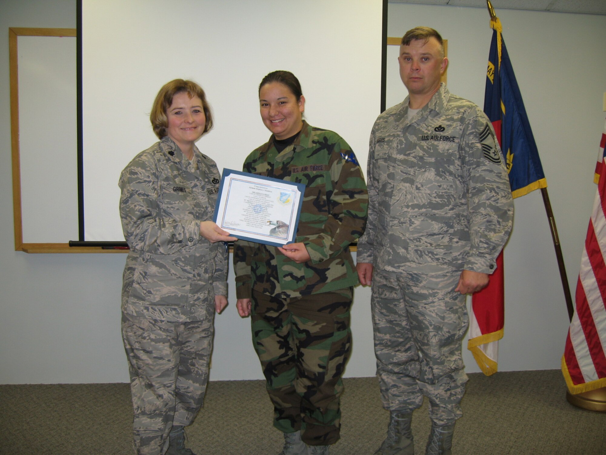 SEYMOUR JOHNSON AIR FORCE BASE, N.C. -- Airman Stephanie Mendoza (middle) receives her certificate of promotion from Lt. Col. Kerri Grimes (left), commander of the 916th Civil Engineer Squadron and Chief Master Sgt. Jeff Jarvis during the March unit training assembly. Airman Mendoza is an operations apprentice with the Air Force Reserve wing.