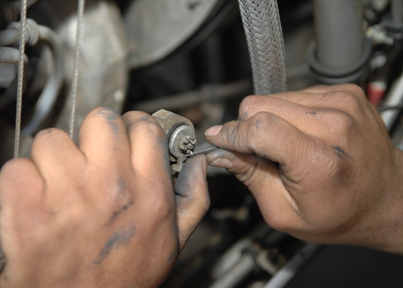 DYESS AIR FORCE BASE, Texas -- Airman 1st Class Kevin Poulton loosens a wire, April 2. Engine Airmen must inspect and fix every part of an aircraft engine, from the huge parts down to the smallest screws and wires. (U.S. Air Force photo Airman 1st Class Jennifer Romig)
