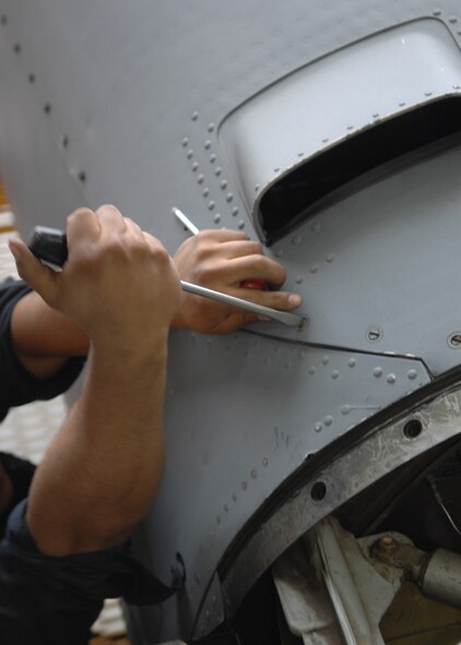 DYESS AIR FORCE BASE, Texas -- Airman 1st Class Kevin Poulton unscrews an engine panel, April 2. When preparing to inspect an engine, a team of two or three Airmen must first remove all the panels and protective coverings to work on the engine itself. (U.S. Air Force photo Airman 1st Class Jennifer Romig)