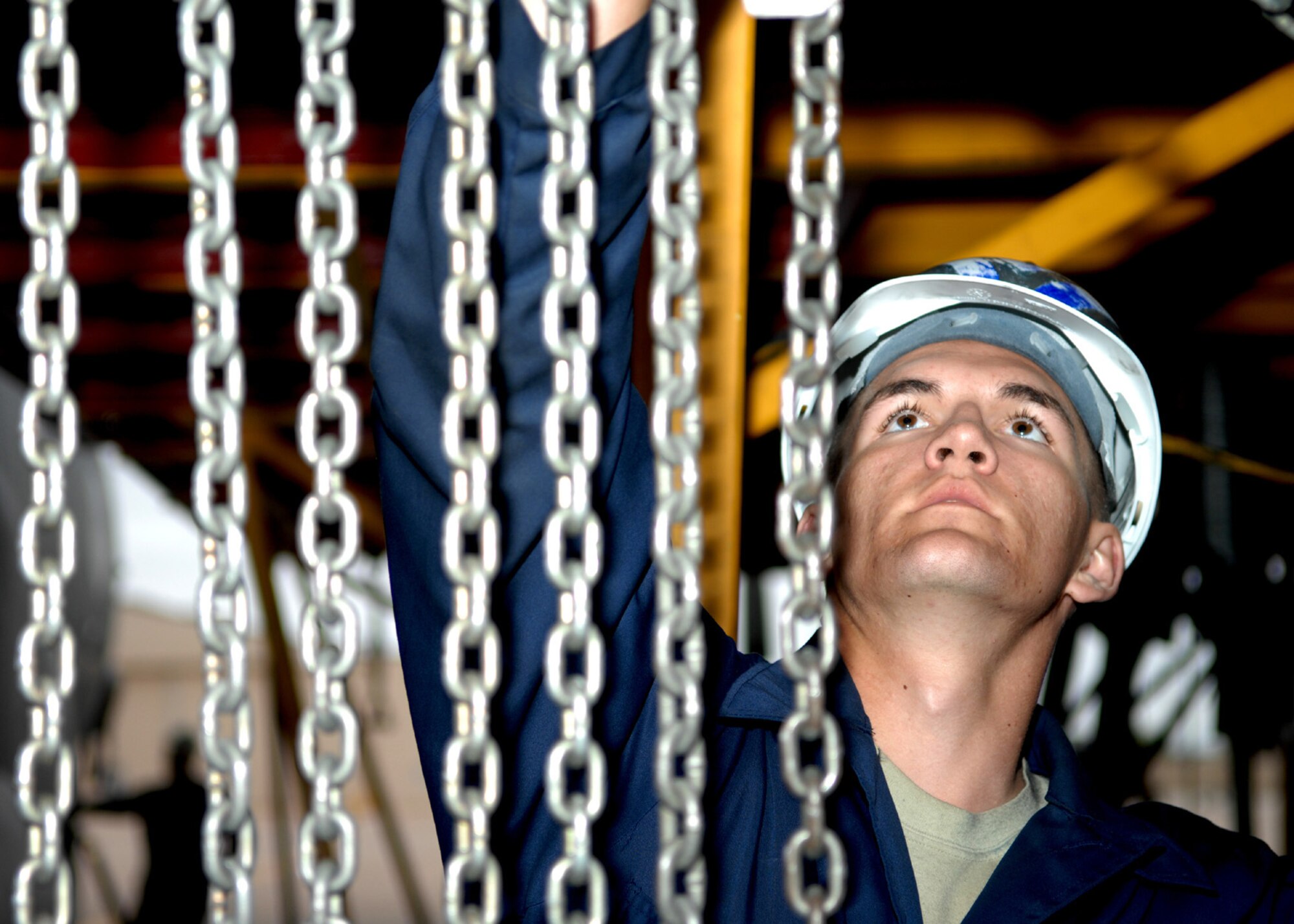 DYESS AIR FORCE BASE, Texas -- Airman 1st Class Seth Duggan hangs aircraft chains, April 2. Part of being a crew chief is cleaning out an aircraft after ever mission, and to inspects everything down to the smallest screws and wires. (U.S. Air Force photo Airman 1st Class Jennifer Romig)