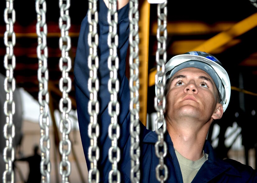 DYESS AIR FORCE BASE, Texas -- Airman 1st Class Seth Duggan hangs aircraft chains, April 2. Part of being a crew chief is cleaning out an aircraft after ever mission, and to inspects everything down to the smallest screws and wires. (U.S. Air Force photo Airman 1st Class Jennifer Romig)