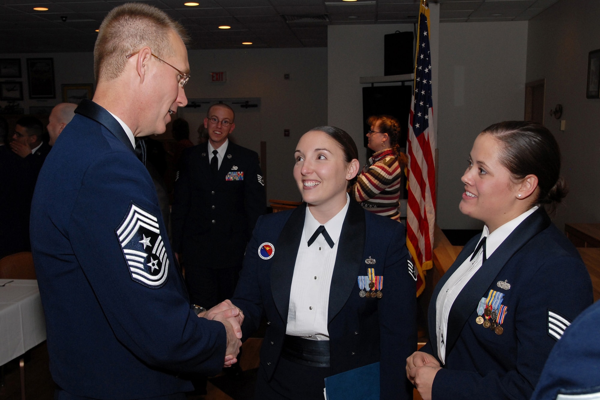 Airmen Leadership School instructors Staff Sgt. Lacie Jo Collins (shaking hands) and Elizabeth Poole thank Air Force Space Command Command Chief Master Sgt. Todd Small for his inspirational address to the graduating class March 25. Chief Small was the keynote speaker. (U.S. Air Force photo/John Turner)