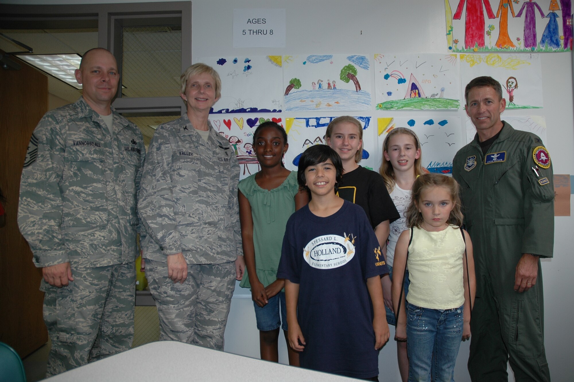 45th Space Wing Command Chief Master Sgt. Dennis Vannorsdall, 45th Medical Group Commander Col. Florence Valley and 45th Space Wing Vice Commander Col. Stephen Butler with some of the participants of the Poster Contest at the Youth Center March 28. (U.S. Air Force photo by Airman 1st Class David Dobrydney)