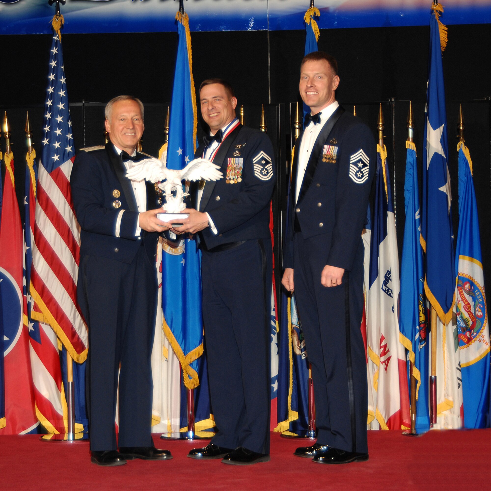 Air Force Materiel Command’s First Sergeant of the Year, Senior Master Sgt. Scott L. Leach (center), poses with Gen. Bruce Carlson, AFMC commander (left), and Chief Master Sgt. William C. Gurney, command chief for AFMC. Sergeant Leach is assigned to the 75th Security Forces Squadron, Hill Air Force Base, Utah. He was selected from nine nominees during a ceremony at the National Museum of the U.S. Air Force April 2. (Air Force photo by Ben Strasser)