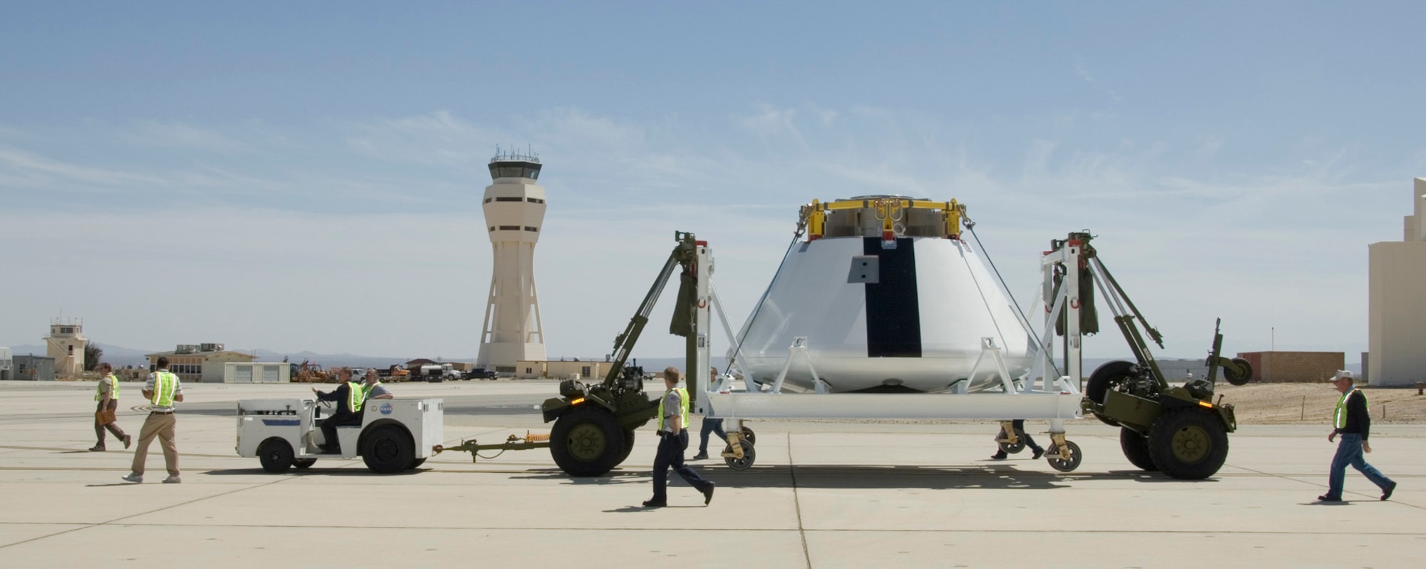 EDWARDS AIR FORCE BASE, Calif. -- Ground crewmen with NASA's Dryden Flight Research Center here escort the boilerplate Orion crew module down the Edwards flightline to Dryden on April 1 after the module was painted in the Edwards paint hangar. (NASA photo by Tony Landis)