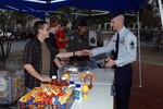 Senior Master Sgt. John Petty (right), Air Force Personnel Center, makes his contribution to the Air Force Assistance Fund March 31 at the base-wide Burger Burn fundraiser in the base exchange and commissary parking lot. (U.S. Air Force photo by Joel Martinez)