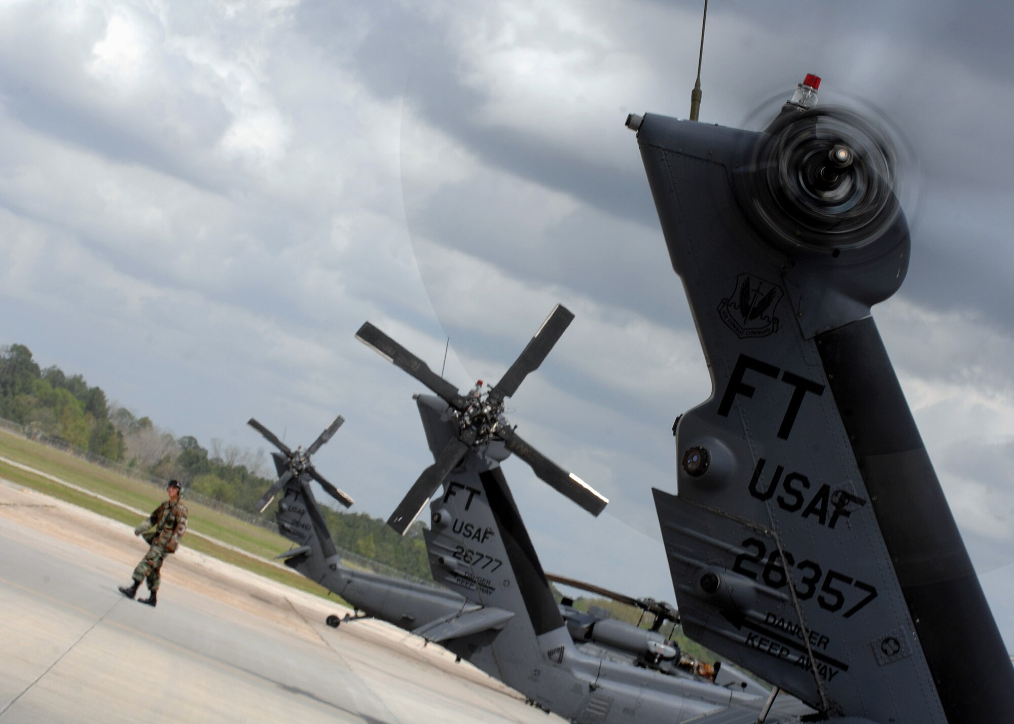An Airman walks off the flightline at Moody Air Force Base, Ga., April 1 while a 41st Rescue Squadron HH-60G Pave Hawk helicopter prepares for take off.  Pave Hawks are frequently tasked for rescue missions, emergency aero-medical evacuation, disaster relief, international aid and counter drug activities. (U.S. Air Force photo/Airman 1st Class Brittany Barker)