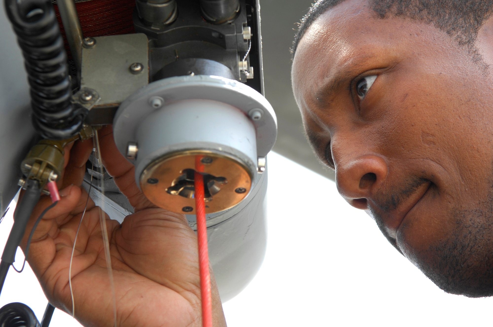 Staff Sgt. Ray Campbell safety-wires a rescue hoist electrical connector April 1 on an HH-60G Pave Hawk helicopter at Moody Air Force Base, Ga.  All critical connectors and bolts on a Pave Hawk are secured with steel safety wire to keep them from falling off.  Sergeant Campbell is an electrical and environmental technician with the 723rd Aircraft Maintenance Squadron.  (U.S. Air Force photo/Tech. Sgt. Parker Gyokeres)