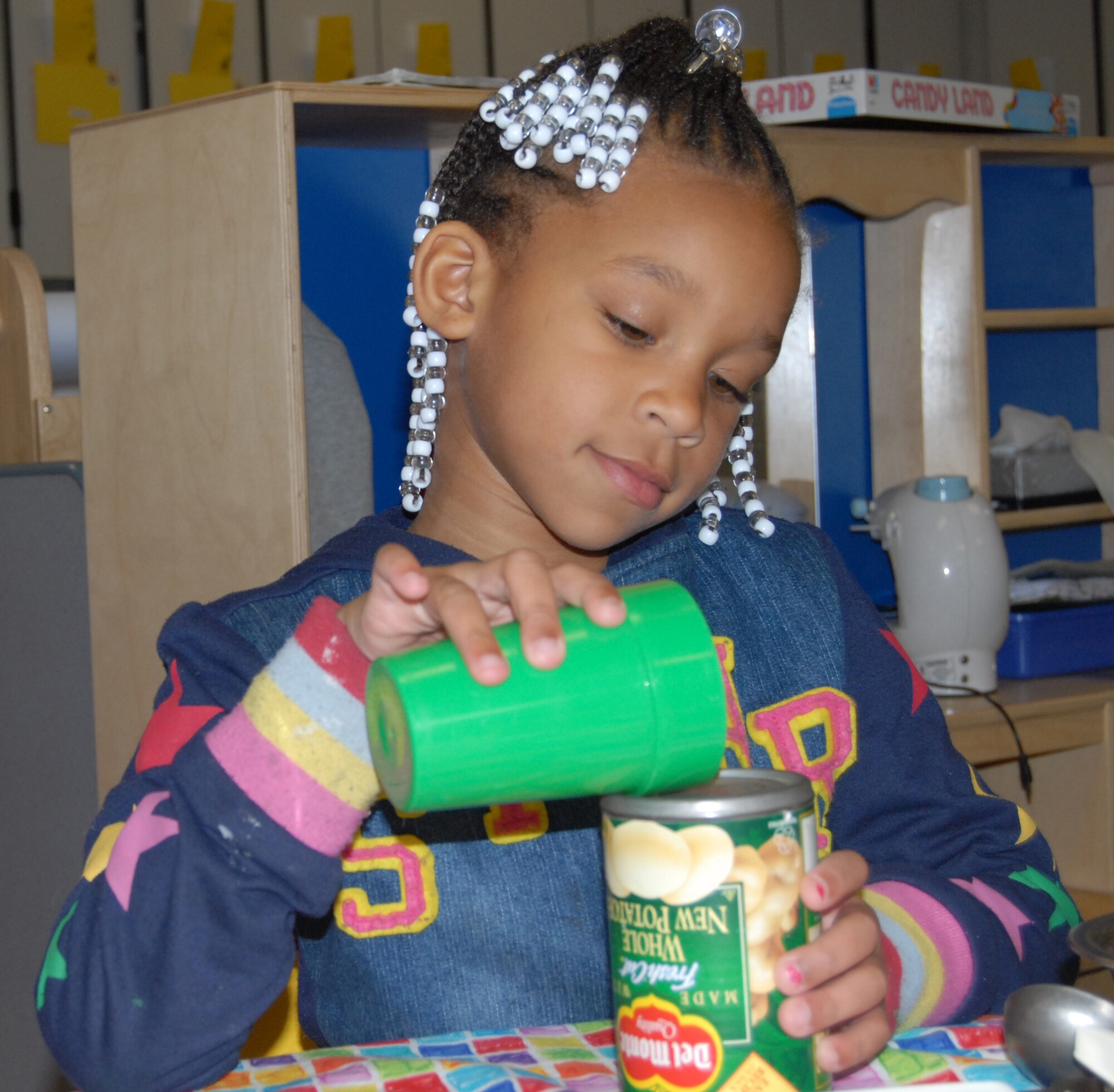 Shionti Morris, 4, plays house at the Child Development Center Monday. Shionti is in preschool. She likes to play house, blocks, do puzzles, play in the sandbox, color, say the pledges, sing songs and dance. Shionti’s favorite singer is Sandra Morrisey, CDC Director, and her favorite song is “The World Is a Rainbow”  which was penned by Ms. Morrisey. Her favorite thing to do at the CDC is to play house. Shionti wants to be a doctor when she grows up. (U.S. Air Force Photo by Airman 1st Class Mindy Bloem) 