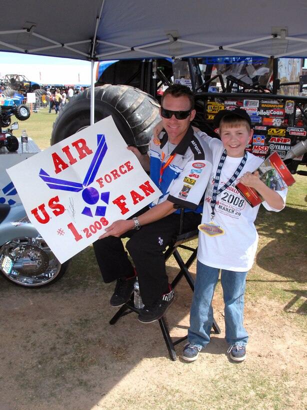 Damon Bradshaw greets a fan during an autograph session at the Monster Jam World Finals March 29 in Las Vegas. Nellis Air Force Base, Nev., provided an honor guard and a 50-Airmen formation carrying state flags at the event. Mr. Bradshaw is the driver of the Air Force Afterburner monster truck. (U.S. Air Force photo/Chief Master Sgt. Gary Emery) 