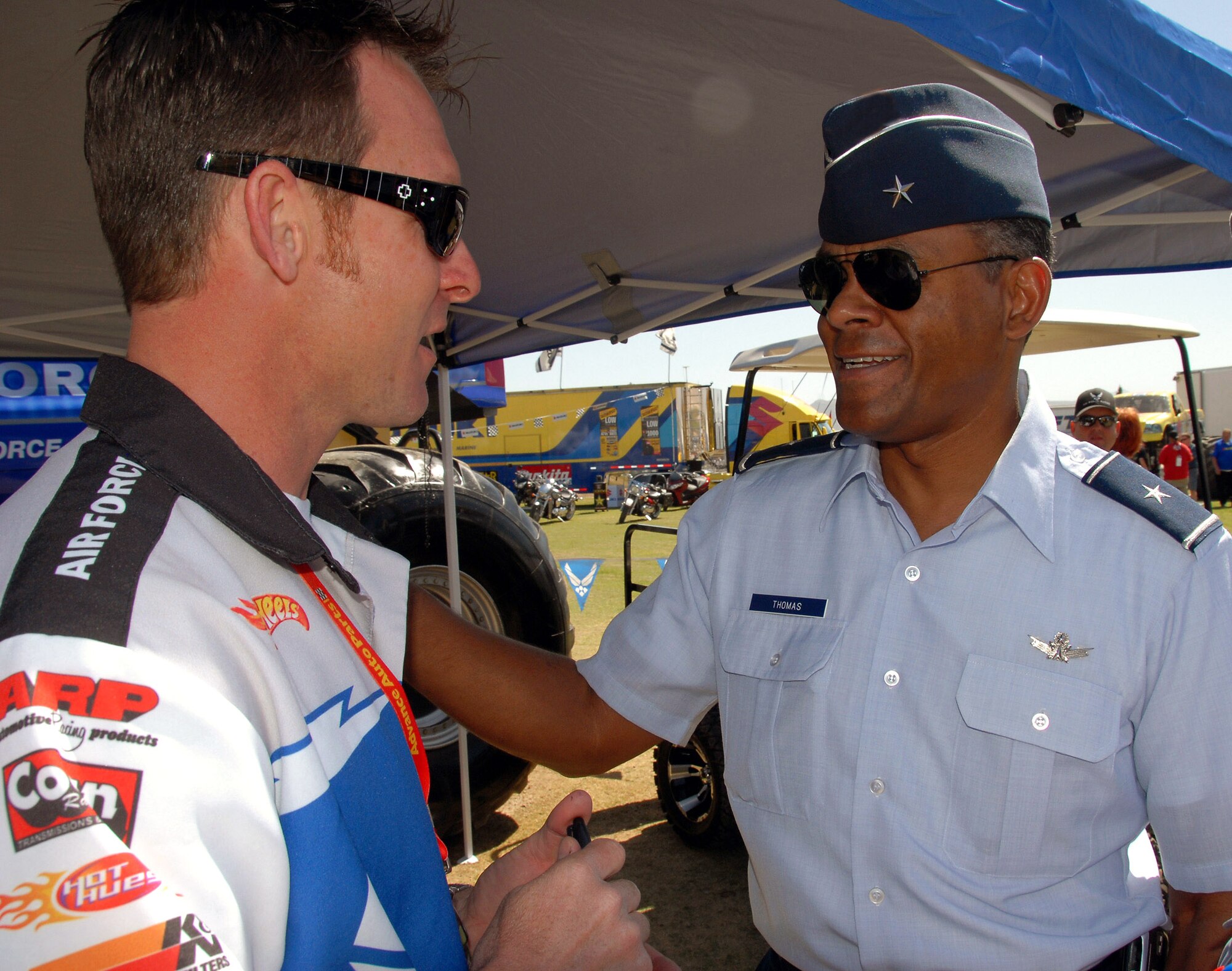 Brig. Gen. Everett H. Thomas (right) gets briefed on the Air Force Afterburner monster truck by Damon Bradshaw March 29 in Las Vegas. Afterburner and Mr. Bradshaw were in Las Vegas to compete in the Monster Jam World Finals. General Thomas conducted a swearing-in ceremony for more than 20 new Air Force members at the event. General Thomas is the Air Force Warfare Center vice commander at Nellis Air Force Base, Nev. Mr. Bradshaw is the driver of the Air Force Afterburner monster truck. (U.S. Air Force photo/Chief Master Sgt. Gary Emery) 
