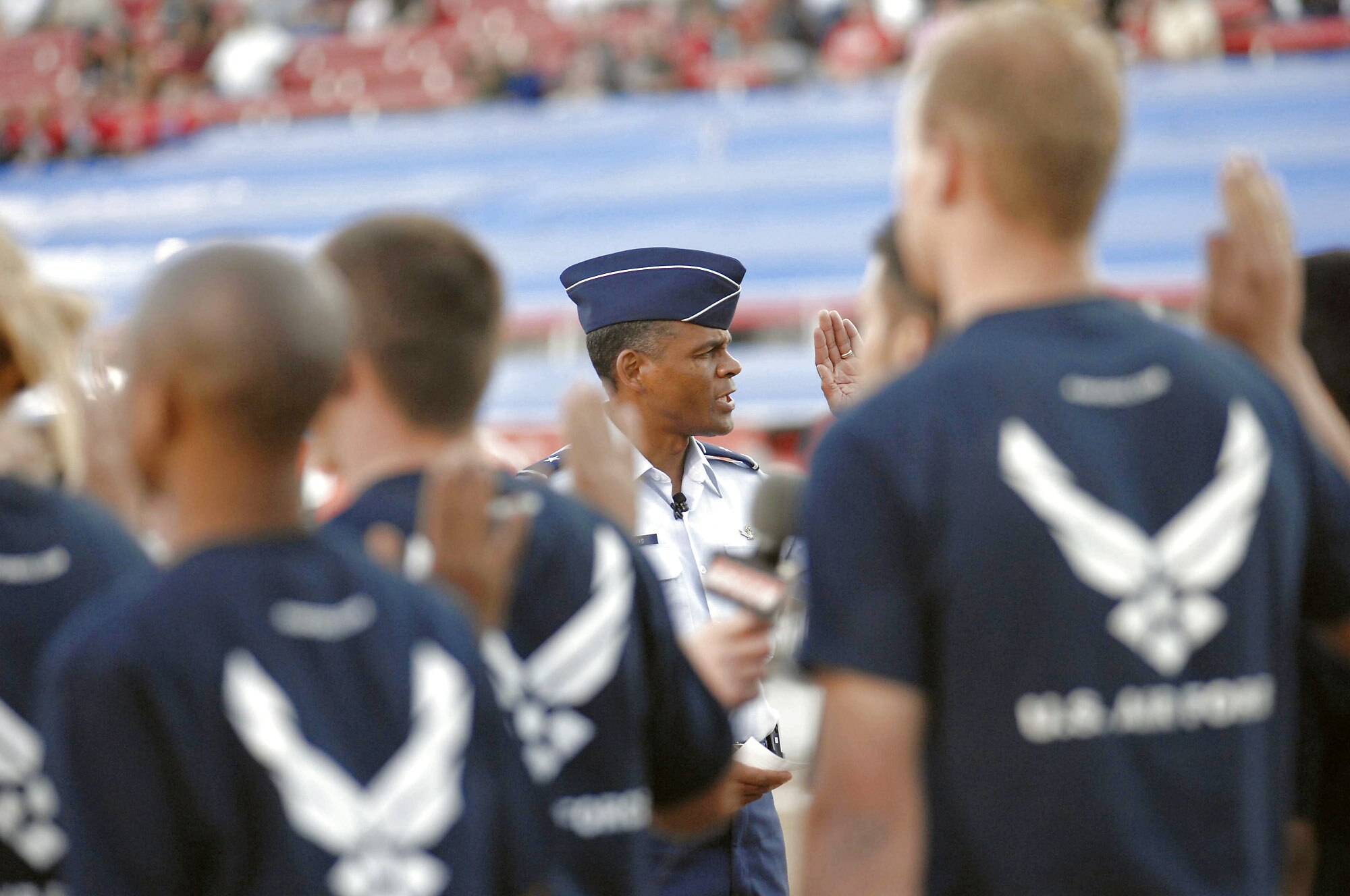 Brig. Gen. Everett H. Thomas administers the oath of enlistment to 20 future Airmen currently in the delayed enlisted program before the start of the Monster Jam World Finals March 29 at Sam Boyd Stadium in Las Vegas. General Thomas is the Air Force Warfare Center vice commander at Nellis Air Force Base, Nev. (U.S. Air Force photo/Senior Airman Larry E. Reid Jr.) 
