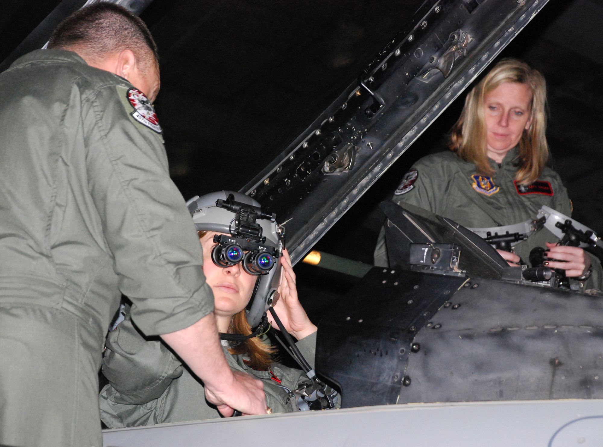 Col Bruce Cox (left), 301st Operations Group vice commander, gives a Night Vision Goggle (NVG) demonstration to Ms. Kate Fitzpatrick, a Professional Staff Member from the U.S. Senate Committee on Appropriations, Washington, D.C. Ms. Fitzpatrick, and Ms. Katy Hagan (right), also a staffer, each received an orientation flight in the 457th Fighter Squadron's F-16, located at the Naval Air Station Fort Worth Joint Reserve Base Carswell Field, Texas, to gain a full understanding into how the Air Force Reserve Command spends it's share of the budget in regards to equipment upgrades and combat capability. (U.S. Air Force Photo/Tech. Sgt. Julie Briden-Garcia)
