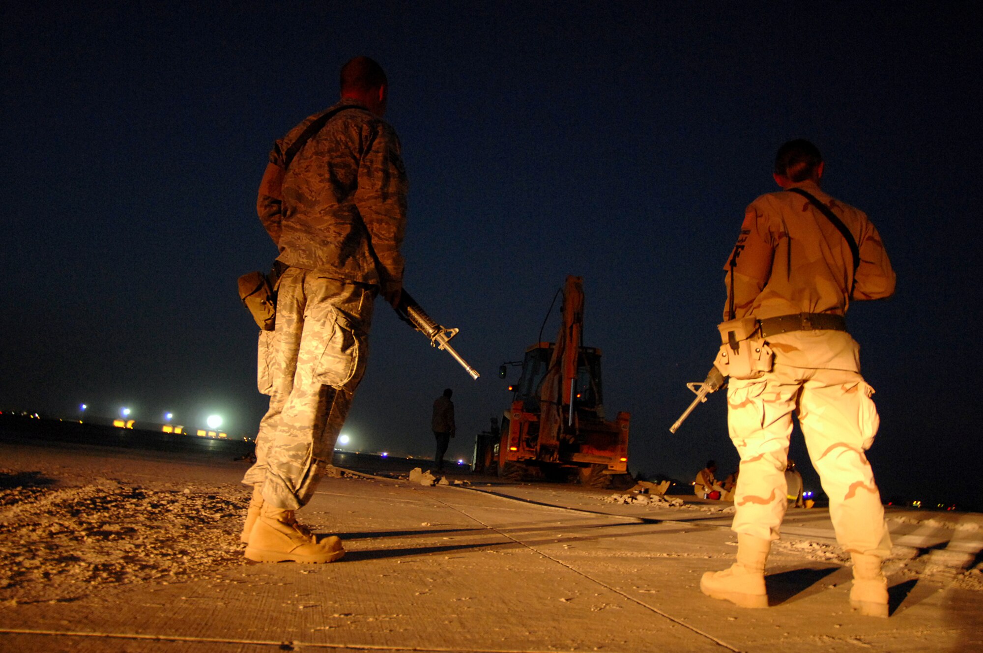 BALAD AIR BASE, Iraq -- Staff Sgts. Jesse Wright and Afton Meeks, 332nd Expeditionary Security Forces Squadron force protection noncommissioned officers, provide over watch as third country nationals work at a construction site here, April 2.  Ensuring the safety of Airmen and assets are at the forefront of the 332nd Air Expeditionary Wing mission; force protection Airmen ensure that mission is fulfilled. The Airmen provide supervision to third country nationals who do various jobs around the base to prevent questionable activities from occurring. Sergeant Wright is deployed from Altus Air Force Base, Okla.; Sergeant Meeks is deployed from Hill AFB, Utah. (U.S. Air Force photo/ Senior Airman Julianne Showalter)