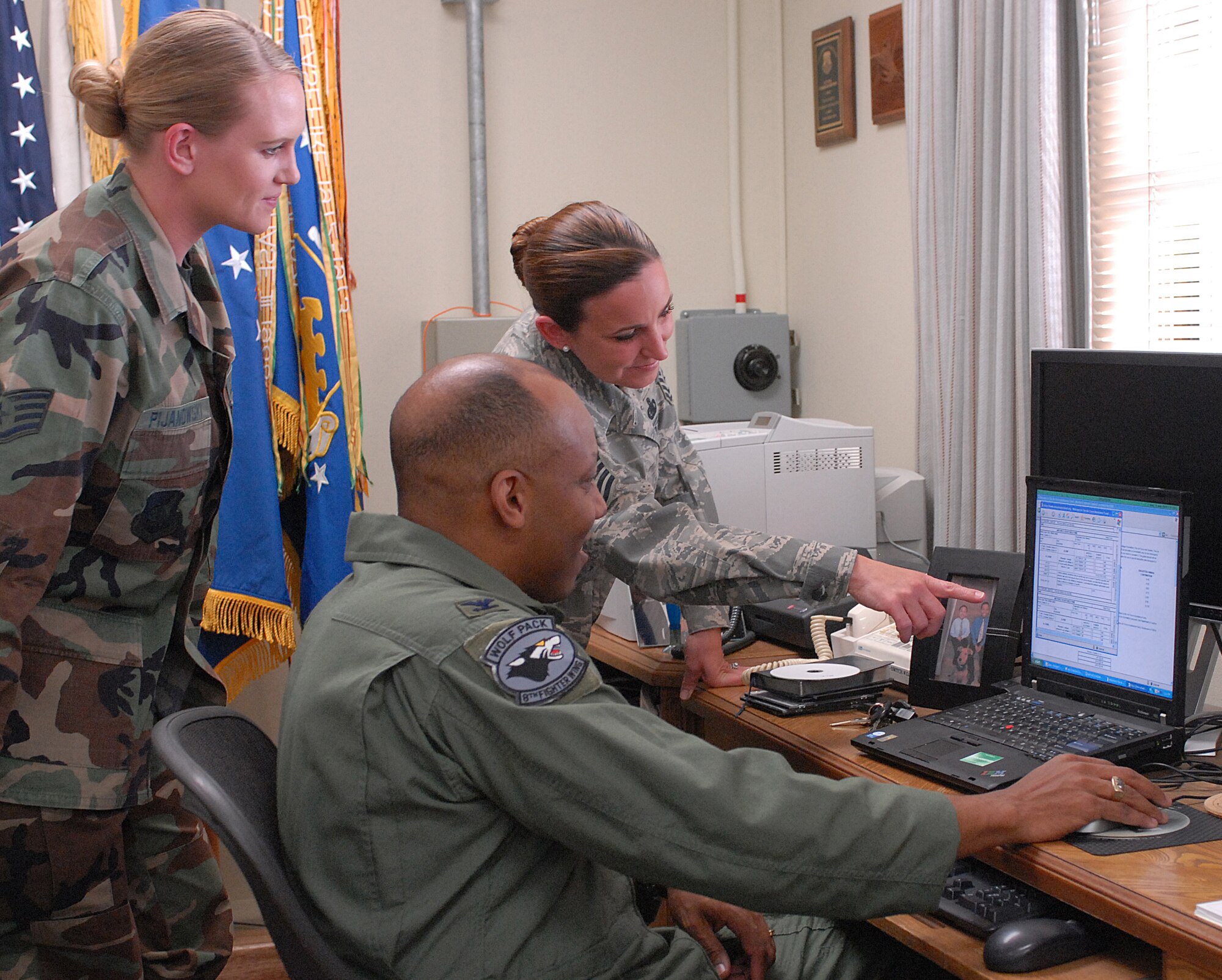 KUNSAN AIR BASE, Republic of Korea -- Master Sergeant Carol Davis, 8th Logistics Readiness Squadron and Staff Sgt. Corin Pijanowski, 8th Fighter Wing military justice paralegal, help Colonel CQ "Wolf" Brown, 8th Fighter Wing commander, sign the Air Force Assistance Fund electronic application here March 31.  The Air Force Assistance Fund helps Airmen with aid in an emergency, educational needs, and widows of Air Force members  The commander initiates a four-week fund raising program for the 8th Fighter Wing by signing a contribution form. (U.S. Air Force photo/Senior Airman Giang Nguyen)