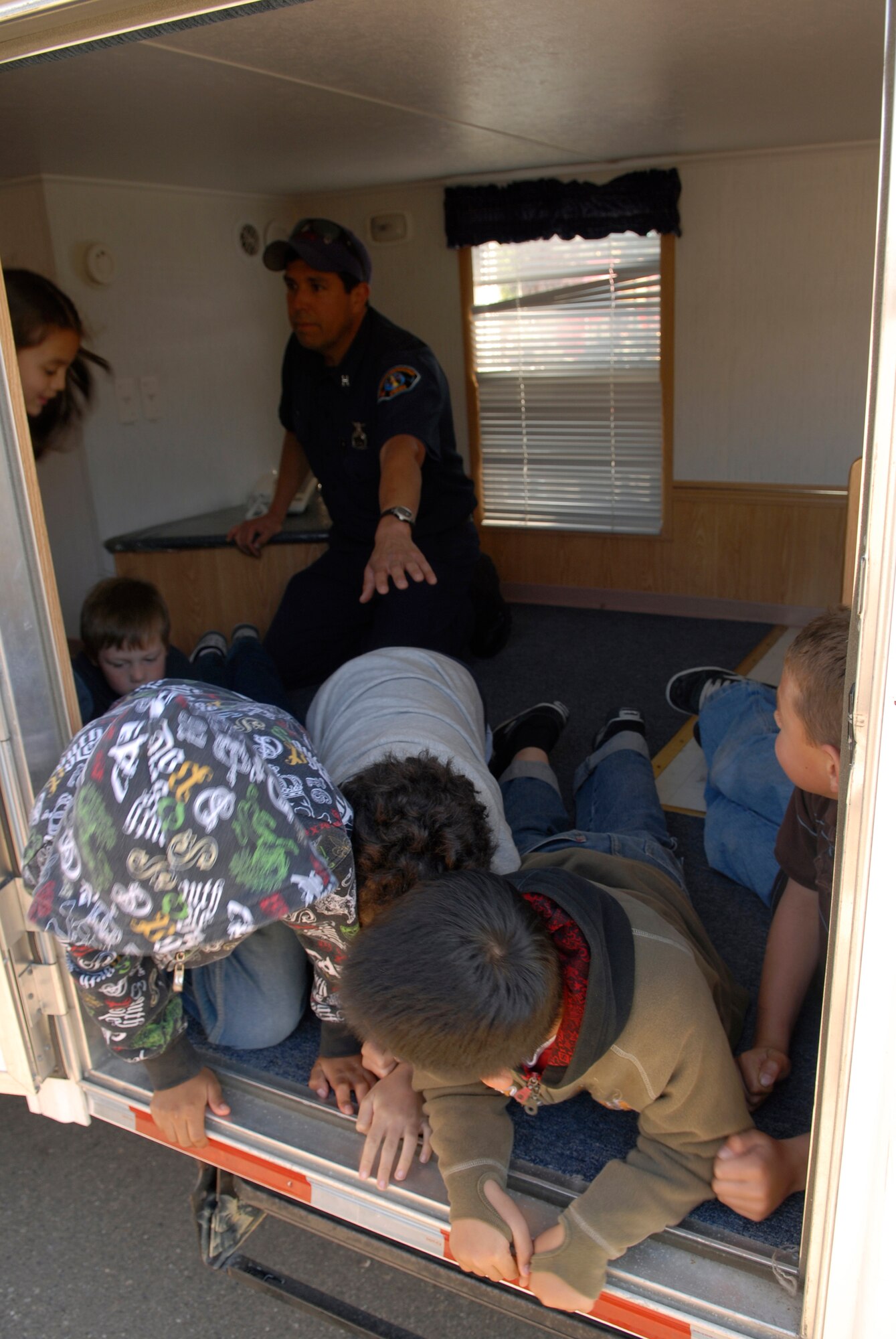 LOMPOC, Calif. -- Marty Silva, a fire fighter with the 30th Civil Engineer Squadron, Vandenberg Air Force Base, Calif., teaches children at the Lompoc Boys and Girls Club to crawl under smoke during a simulated fire on April 3. The VAFB fire department is involved with the local community to educate citizens to be more conscience of fire hazards and the importance of having a household fire safety plan. (U.S. Air Force photo/Airman 1st Class Christian Thomas) 



