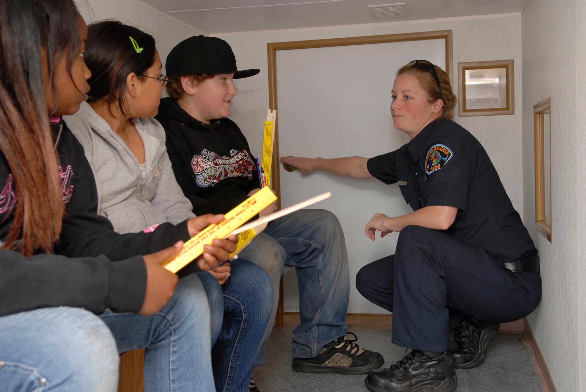 LOMPOC, Calif. -- Erin Butler, a fire fighter with the 30th Civil Engineer Squadron, Vandenberg Air Force Base, Calif., speaks to children at the Lompoc Boys and Girls Club about evacuation procedures if a smoke detector goes off while sleeping on April 3. The VAFB fire department is involved with the local community to educate citizens to be more conscience of fire hazards and the importance of having a household fire safety plan. (U.S. Air Force photo/Airman 1st Class Christian Thomas) 
