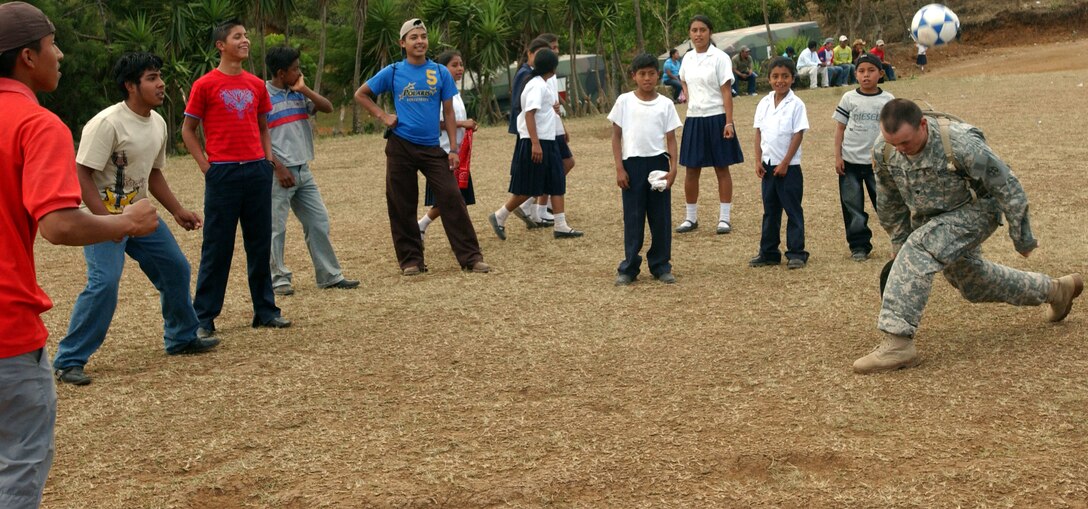 Spc. Cecil L. Lawson of Sterling, Ill., plays soccer with children  in Florida de Marcala during the opening ceremony for Beyond the Horizon, a joint endeavor between the U.S. and Honduran militaries to provide medical services to Honduran citizens and complete construction projects.