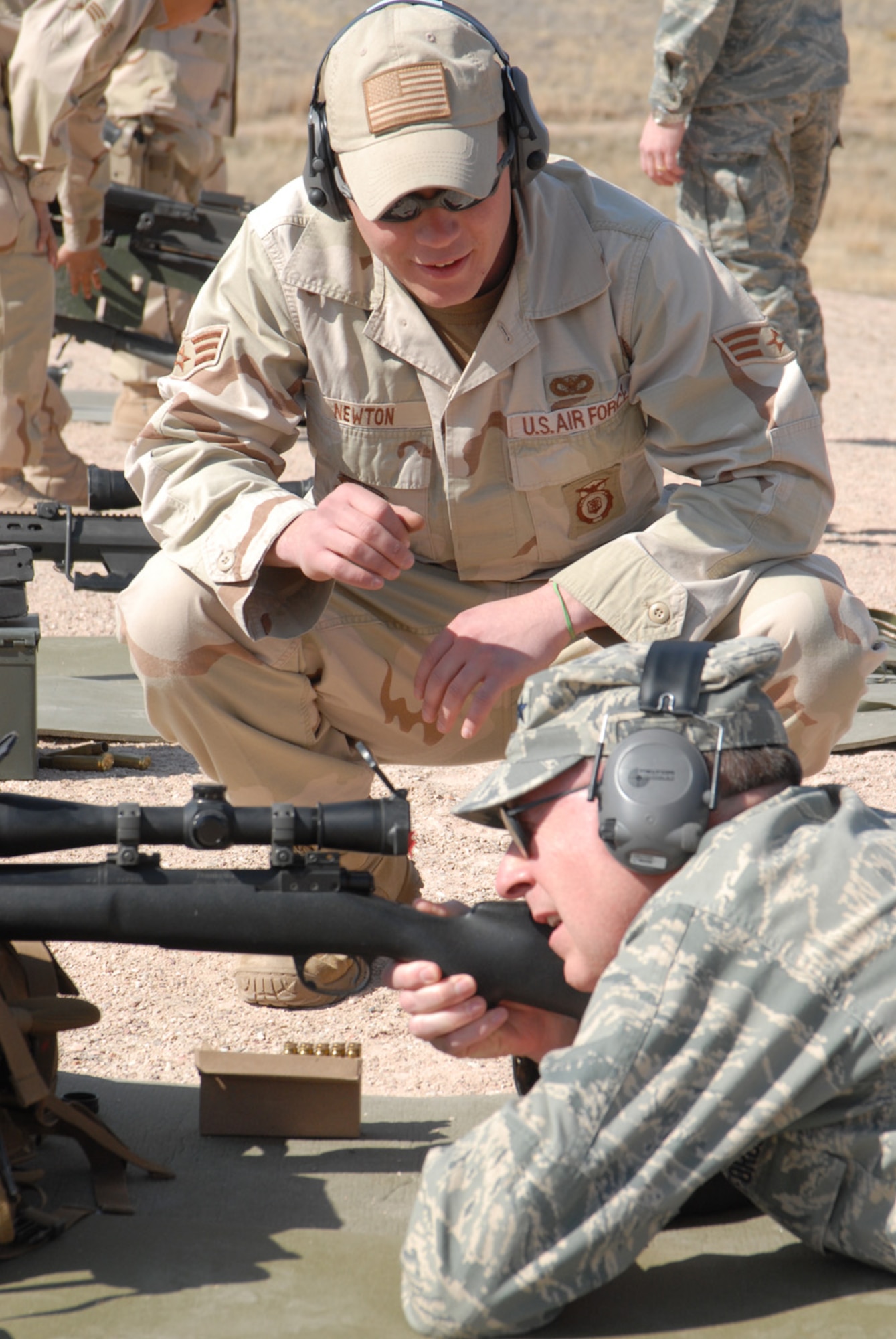 Gen. C. Robert Kehler, Air Force Space Command commander, shoots a weapon at the Guernsey Regional Training Center March 25. Senior Airman Joshua Newton, 90th Ground Combat Training Squadron, helps the general with proper weapon procedures. General Kehler visited as part of a familiarization tour to the space wings (U.S. Air Force photos/Berni Ernst).